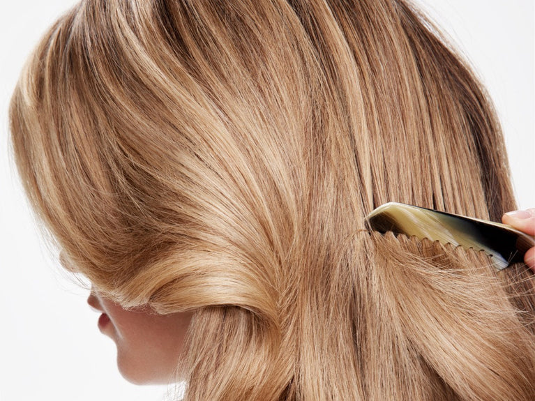 donna bionda che pettina i capelli