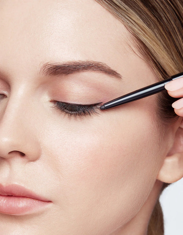Tenere la pelle ben tesa per creare una trama omogenea. Partendo dall’angolo esterno dell’occhio, tracciare, appena sopra la rima ciliare, una linea con Defining Liner, fino all’angolo interno dell’occhio. Usare lo sfumino, nel lato opposto rispetto alla punta, per creare il look desiderato.